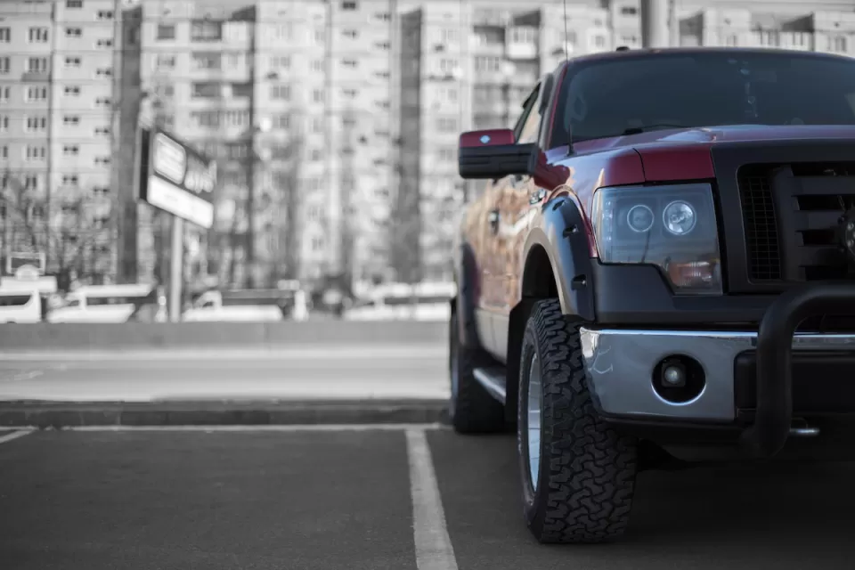Low close-up of front of large parked pick-up truck.